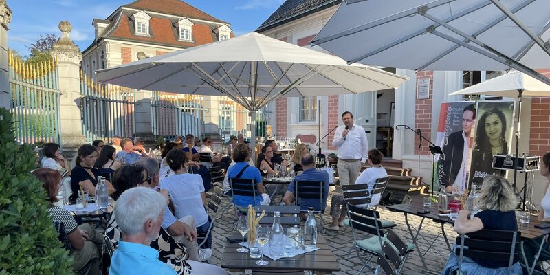 CorFactum Event mit TeilnehmerInnen im Freien bei Vortrag in Bruchsal vor dem Schloss